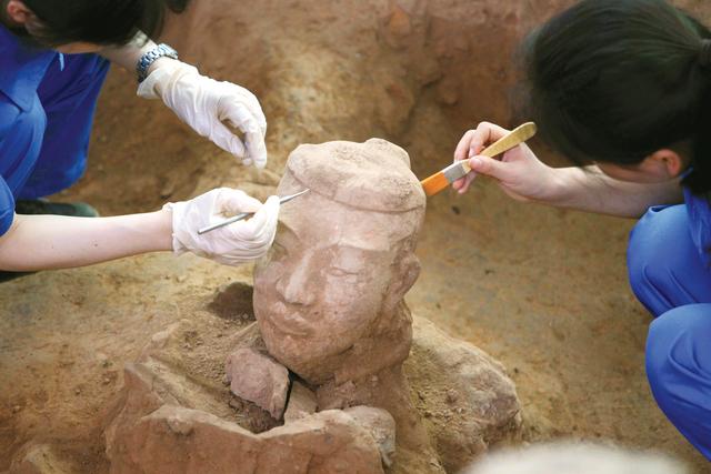 This picture taken on June 9, 2012 shows Chinese archaeologists at work in the extended excavation of the Pit One of the Terracotta Warriors and Horses Museum in Xian, carefully uncovering using delicate equipment to help preserve the detailed work in their original production more than 2,000 years ago, of the latest terracotta warrior find in Xian, China's Shaanxi province. Excavations in China have unearthed a stunning new collection of 2,000-year-old terracotta warriors and hundreds of other artefacts, as Chinese archaeologists unveiled 120 new terracotta warriors at the Qin Shihuang Unesco World Heritage site in Shaanxi province. CHINA OUT AFP PHOTO