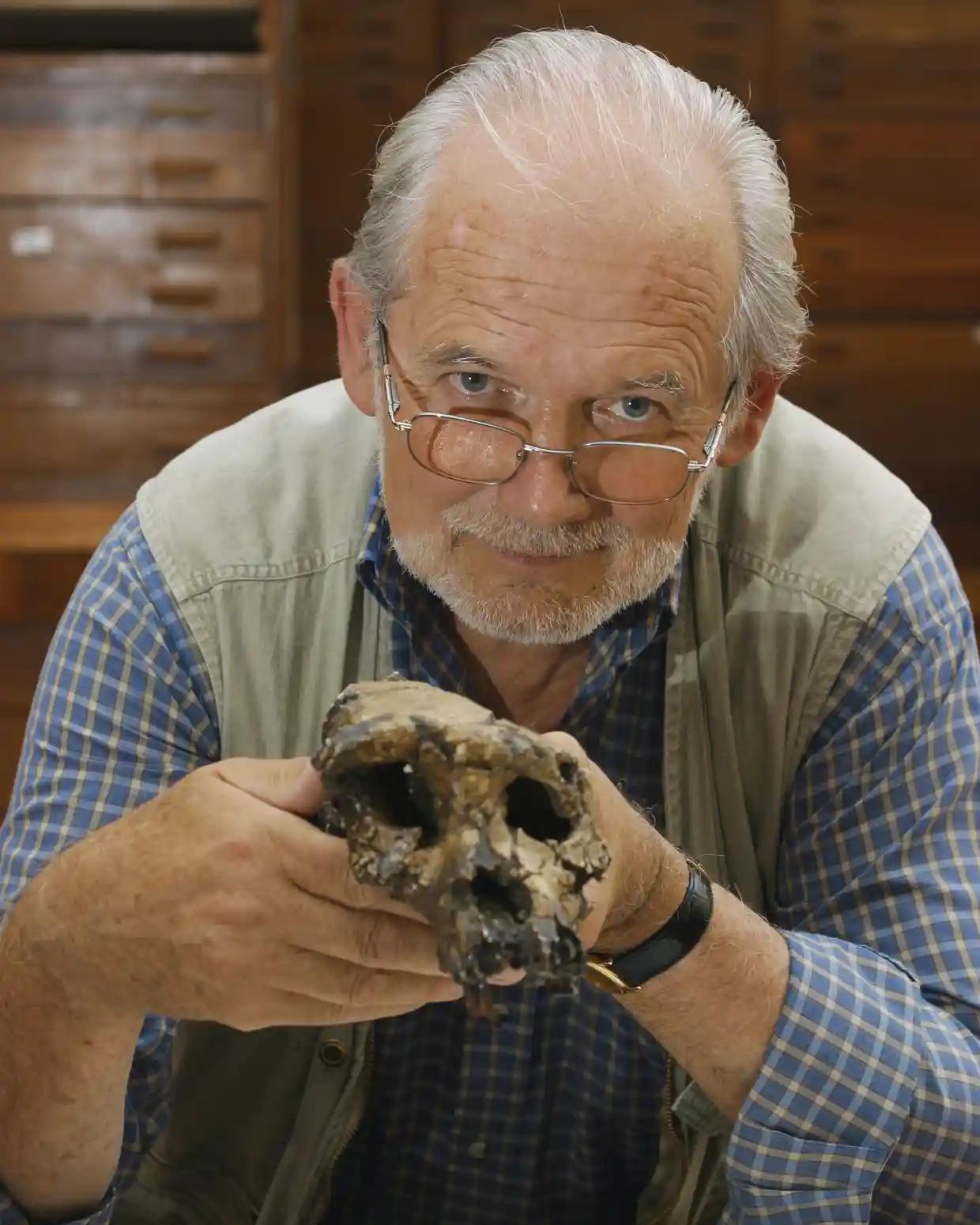الأستاذ ميشيل برونيه من جامعة بواتييه يحمل جمجمة توماي