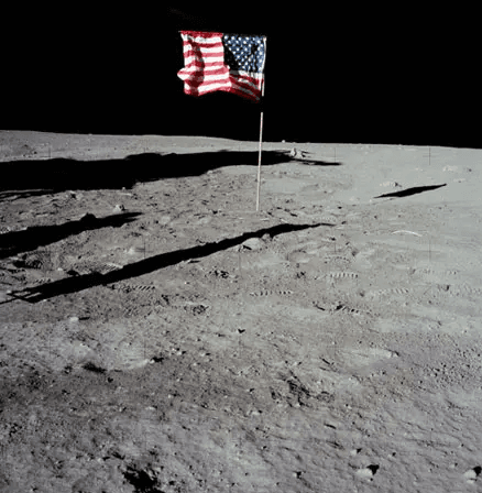 A flag on the moon</p>
<p>Description automatically generated