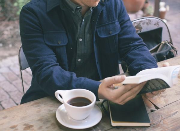 شخص يقرأ كتاب ويحتسي القهوة آداب القراءة