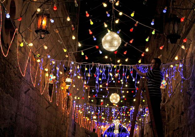 A Palestinian Muslim man, decorates an alley of Jerusalem's old city with festive lights in preparation for the Muslim holy month of Ramadan, Friday, Aug. 21, 2009. The holy month of Ramadan, when observant Muslims fast from dawn to dusk, will begin Saturday. (AP Photo/Muhammed Muheisen)