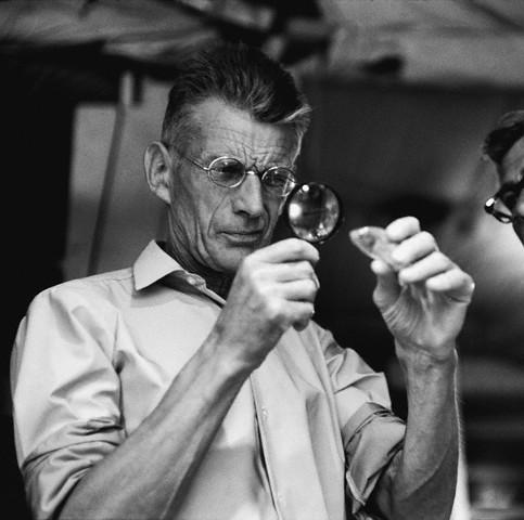 1964, New York, New York, USA --- Samuel Beckett on the set of his movie, , looking at a fish through a magnifying glass. --- Image by © Steve Schapiro/Corbis