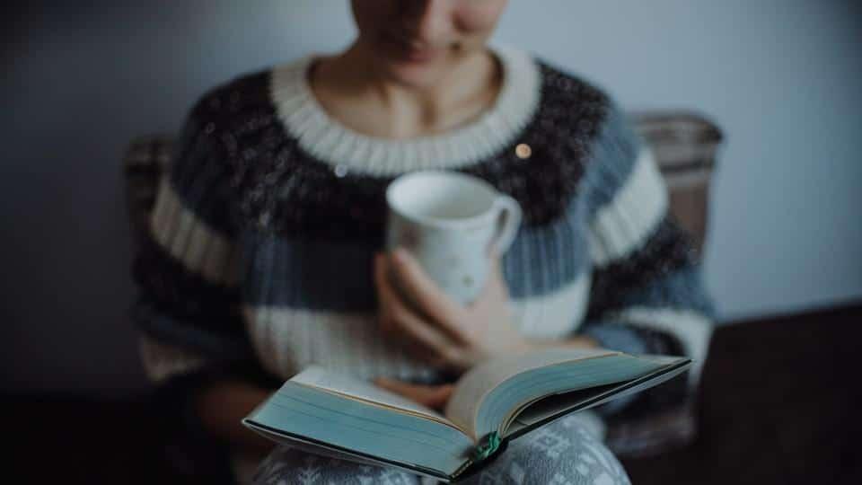 سيدة تشرب قهوة وتقرأ كتابًا