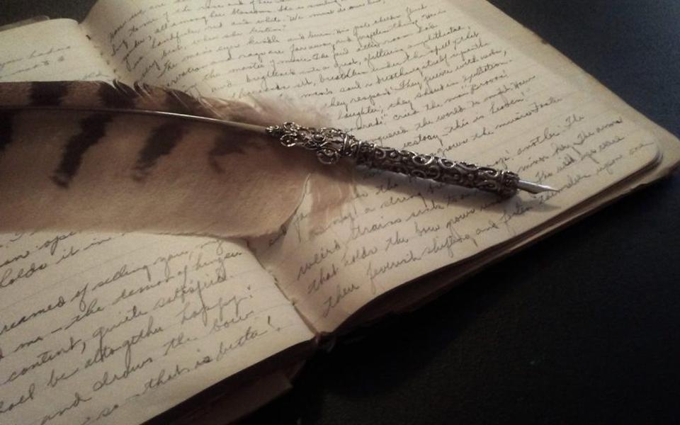 قلم بريشة وصفحات مكتوبة