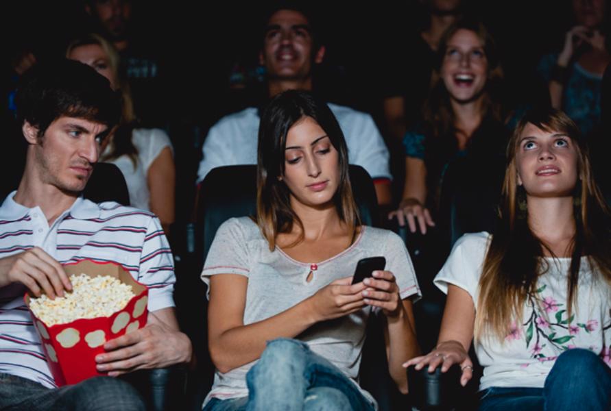 شخص يتفحص الانترنت في السينما - أشخاص لا تذهب معهم إلى السينما 