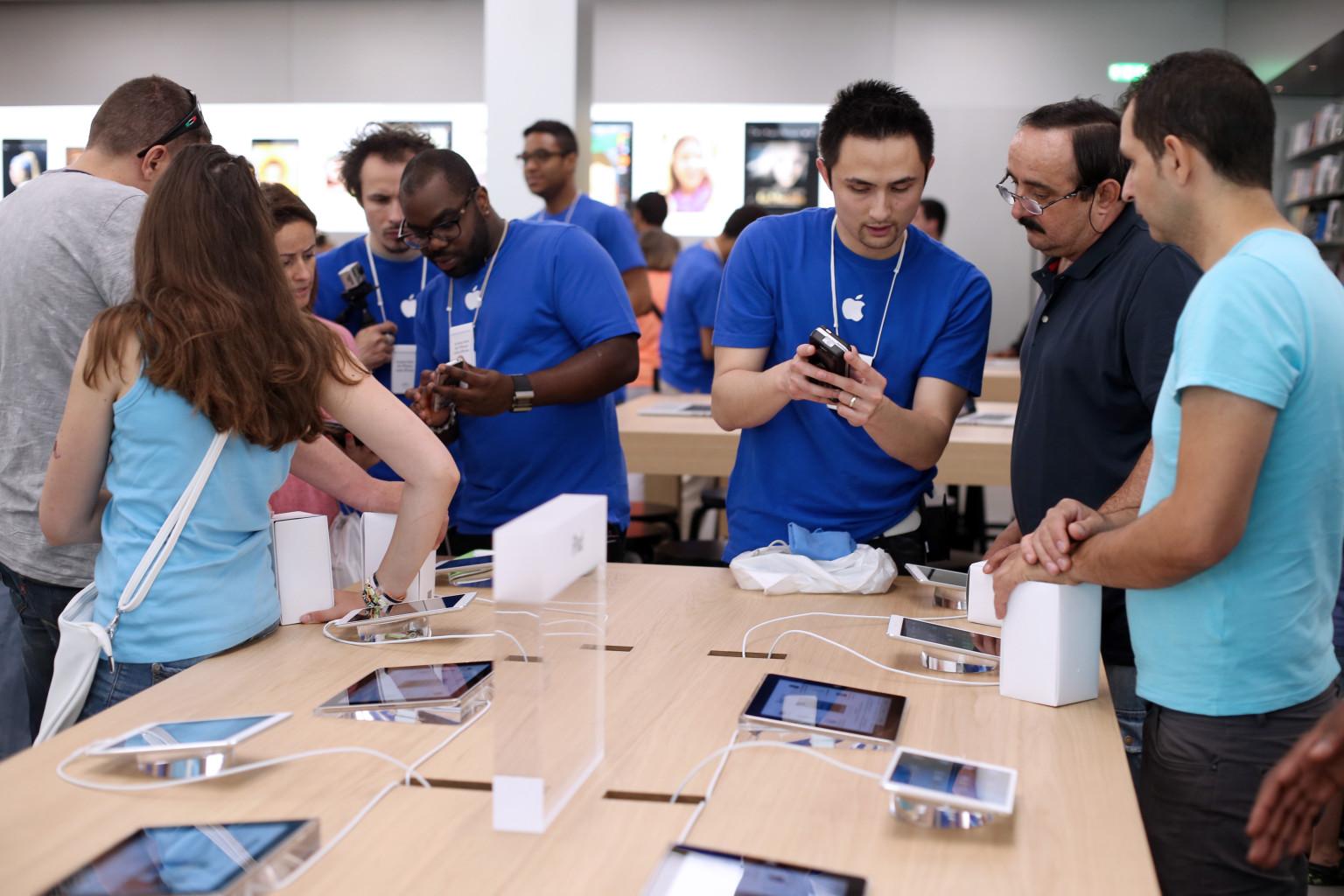 Employees show to customers Apple's iPhone 5 smartphones over iPads in a new Apple store on July 6, 2013 in Rosny-sous-Bois, near Paris. AFP PHOTO / THOMAS SAMSON (Photo credit should read THOMAS SAMSON/AFP/Getty Images)