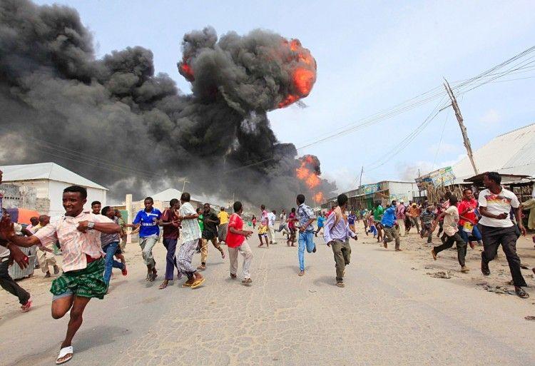 People escape from the direction of a huge fire-ball after an accidental explosion at a petrol storage facility within the former U.S. residential housing in Mogadishu